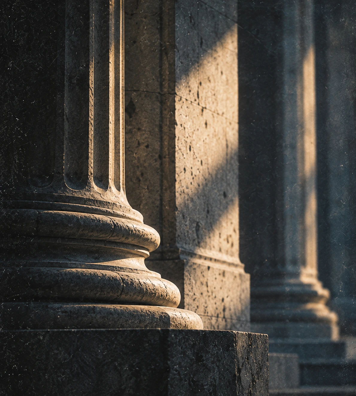 Sunlit stone columns on the facade of a historic building.